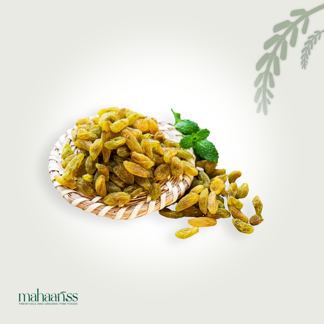 Natural green raisins in a basket with mint leaves, organic dried fruit on white background.