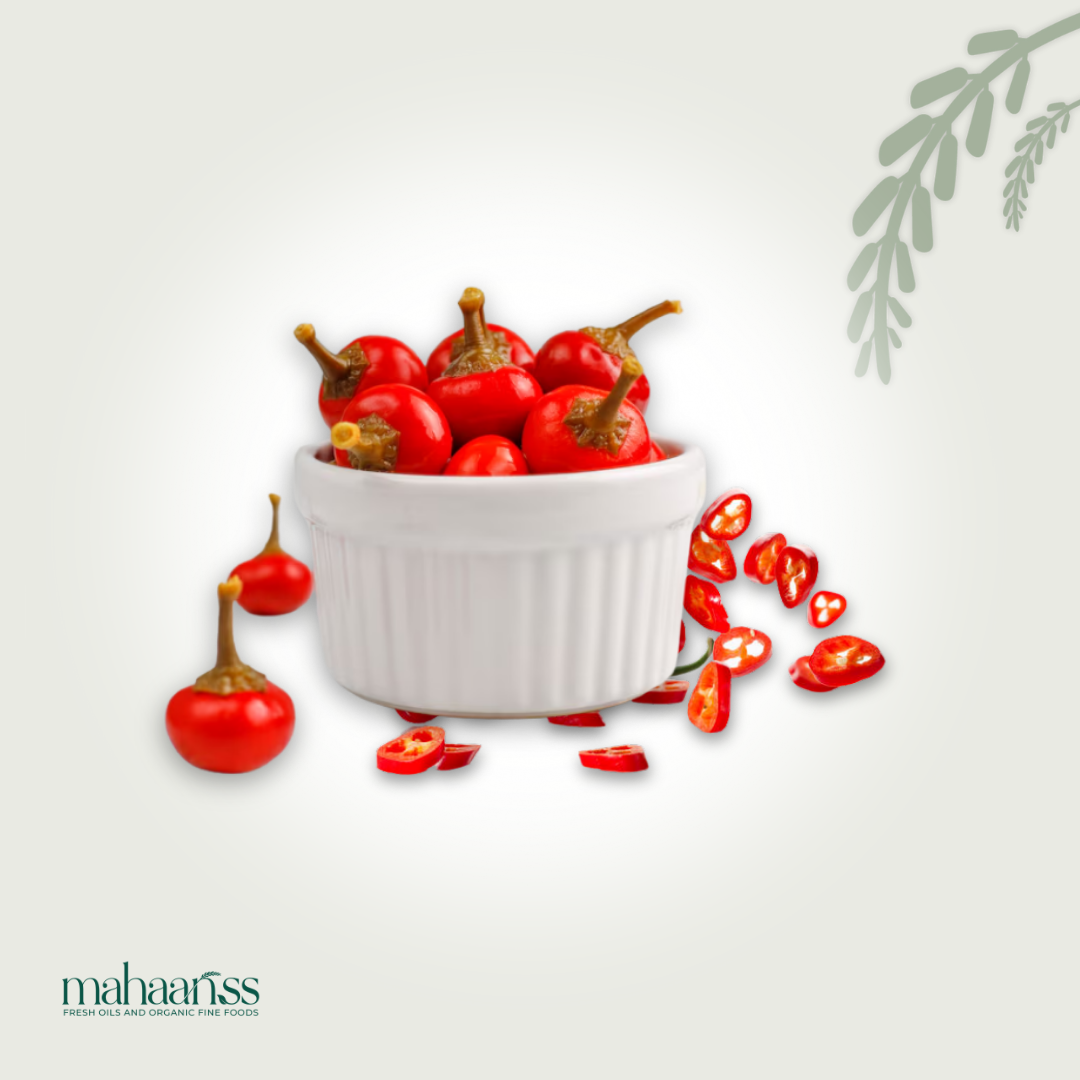 White bowl filled with red chili peppers on a light gray background