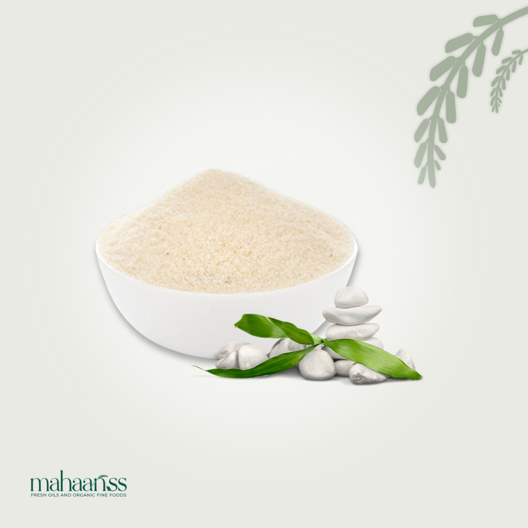 White bowl filled with a white powdery substance on a light gray background with green leaves.