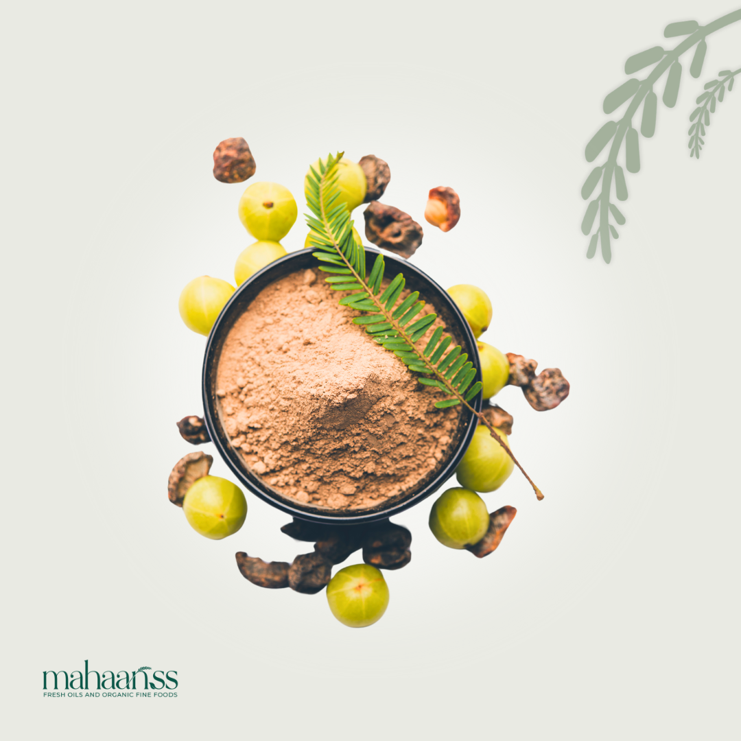 Spice mix in a bowl with green leaves and fruits on a light gray background, featuring the brand 'mahaanss'.