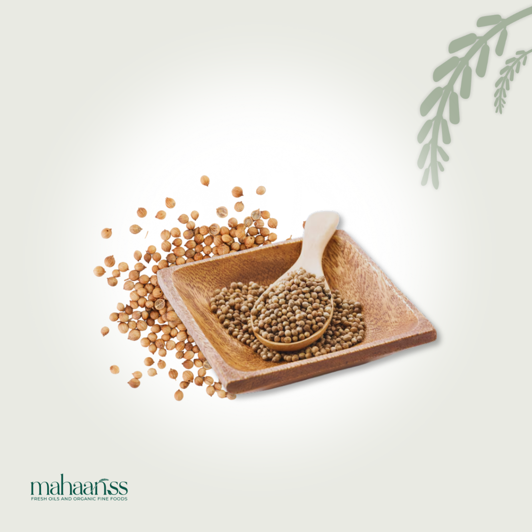 Organic coriander seeds in a wooden bowl with a spoon and loose seeds on a light background