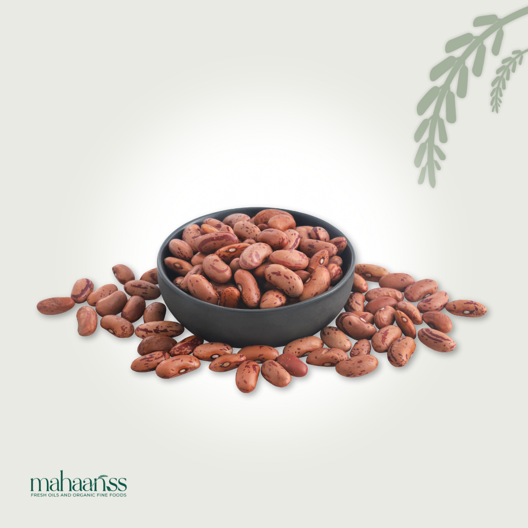 Black bowl filled with Organic Pinto Beanss on a light gray background with 'mahaanss' branding.