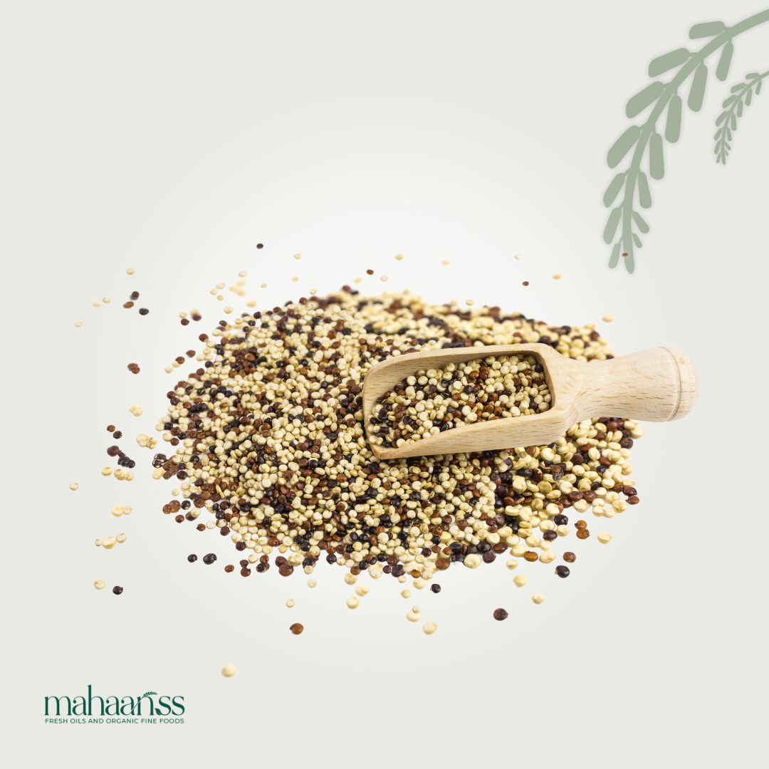Wooden scoop with organic tricolor quinoa on a light background, featuring the brand 'mahaanss'.