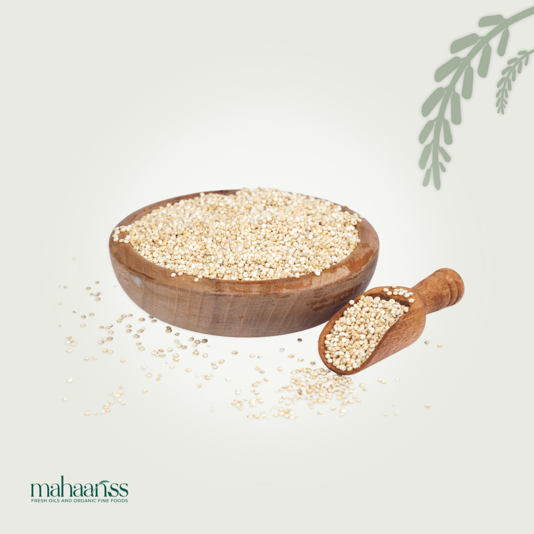 Wooden bowl and scoop filled with quinoa seeds on a light background, with 'mahaanss' brand visible.