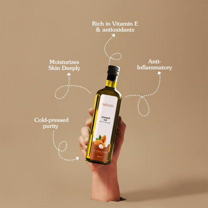 Bottle of almond oil held in a hand with text highlighting benefits on a beige background