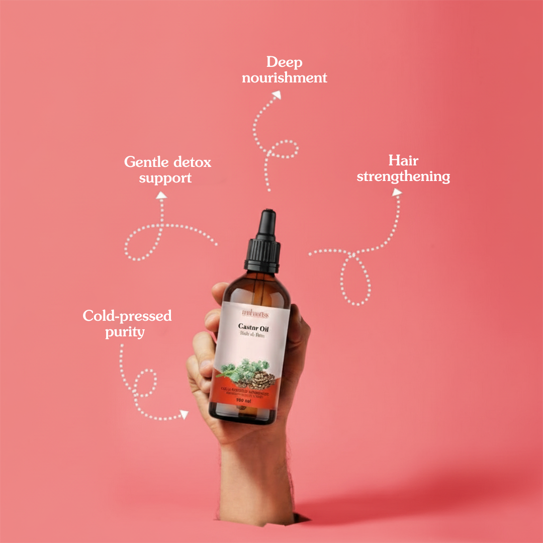 Hand holding a bottle of Castor Oil with text on a pink background