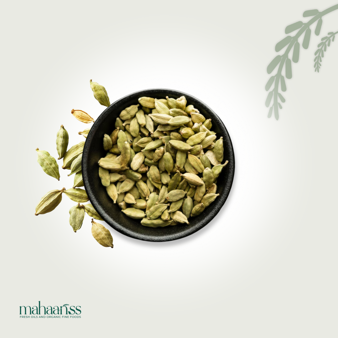 Black bowl filled with green cardamom pods on a light gray background, featuring the 'maharajjiss' brand.