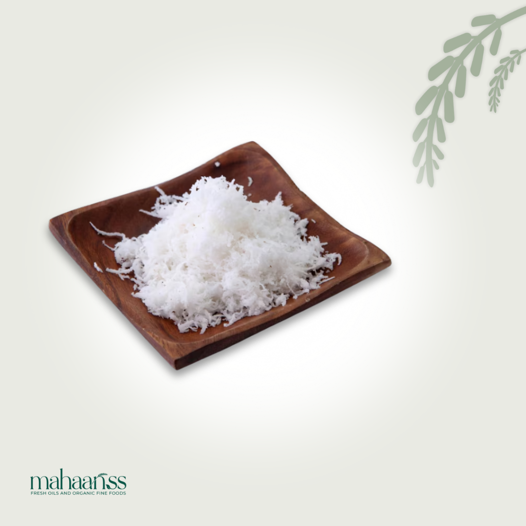Fine natural desiccated coconut on a wooden plate, organic superfood, isolated white background
