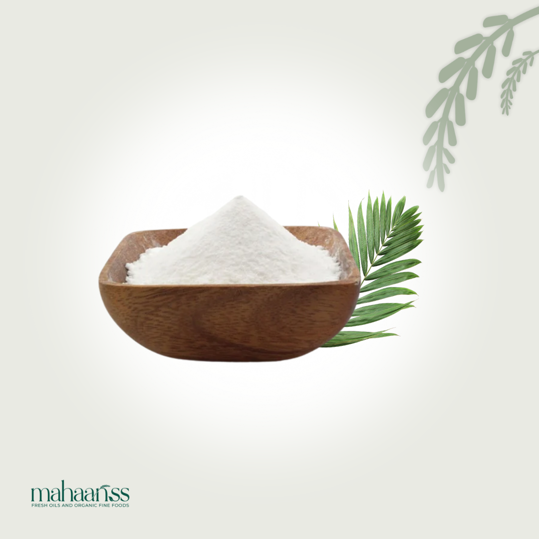 Natural desiccated coconut in wooden bowl with palm leaf on light background