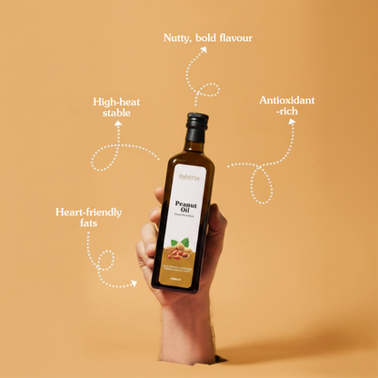 Hand holding a bottle of peanut oil with text highlighting its benefits on an orange background